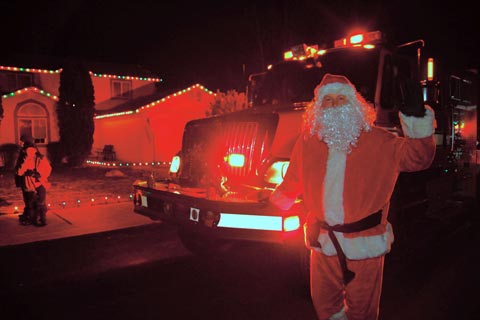 City of Bend Santa Express. Santa Claus standing in front of City Fire truck.