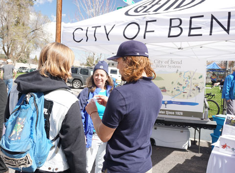 City Utility Department employees talking to community members at Earth Day booth