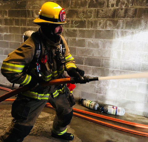 City of Bend firefighter training with firehose.