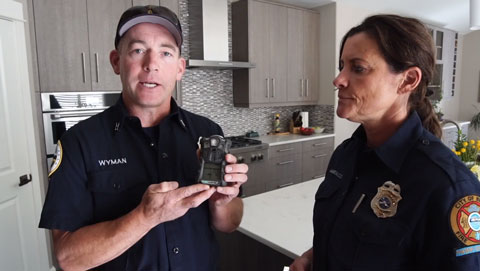 Two EMS staff demonstrating how to use a carbon monoxide detector.