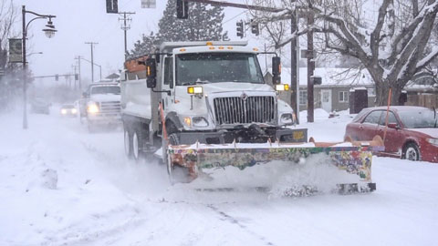 Snowplow plowing Bend street.