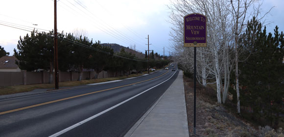 Roadway with a Bend neighborhood sign next to it.