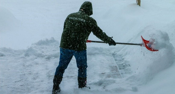 Man shoveling a snowy sidewalk.