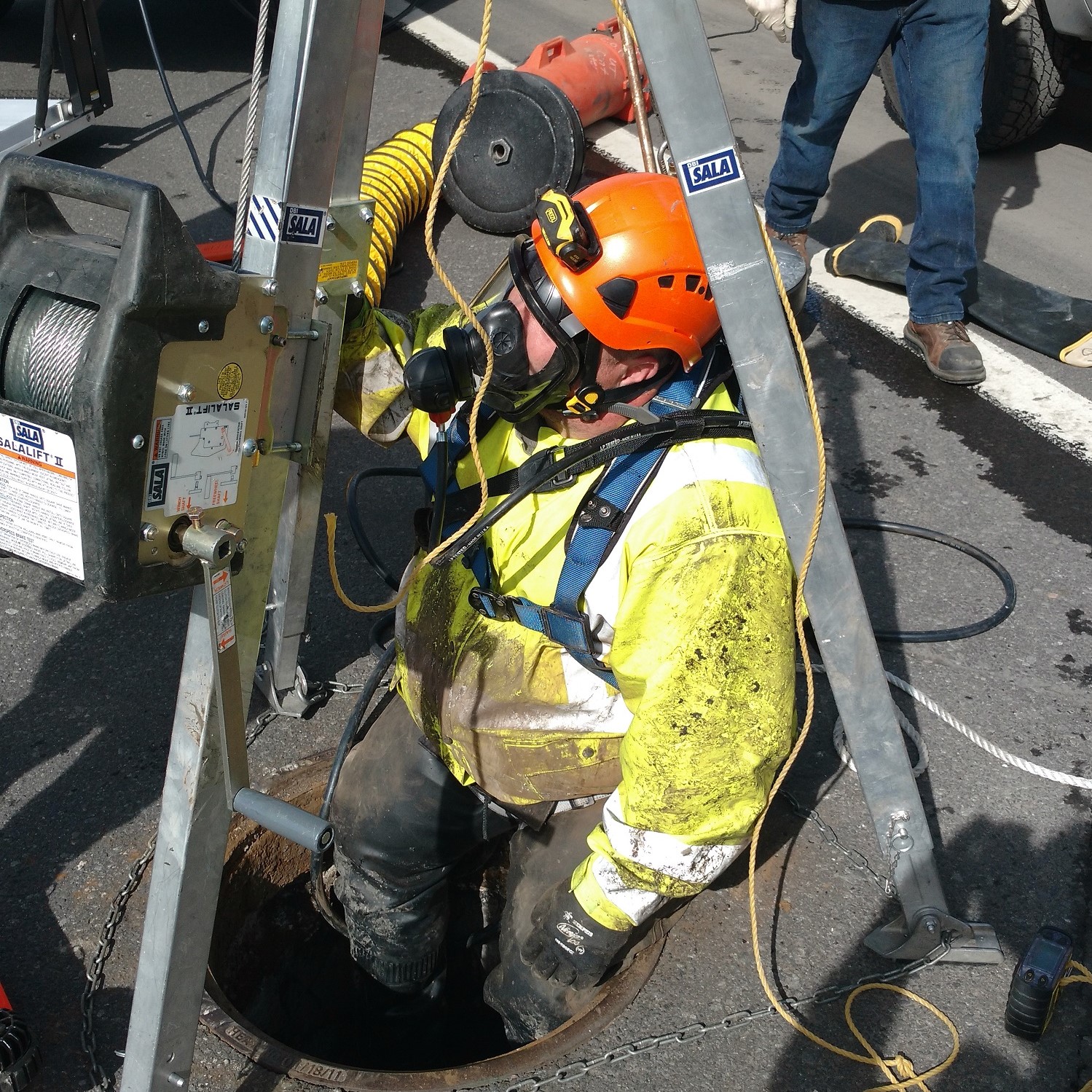 Utility crew entering manhole.