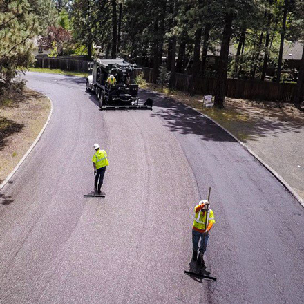 Crew applying a slurry seal to a Bend street.