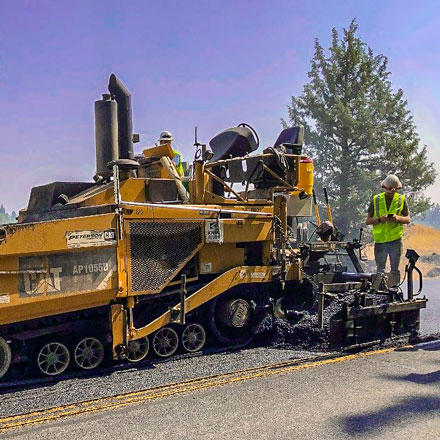 Street crew resurfacing a street.