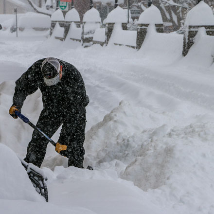 Man shoveling snow after record snowfall.