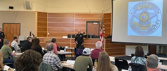 Police officer speaking to a group of people.