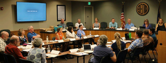 Group of people meeting in Council Chambers.