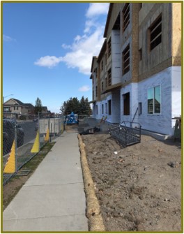 Construction site with clean sidewalk perimeter control wattle and fencing