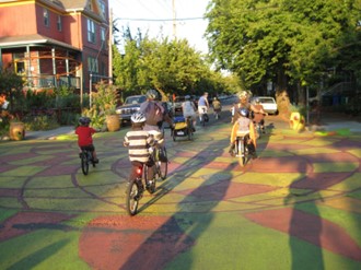 A group of kids riding bikes on a street in a neighborhood.