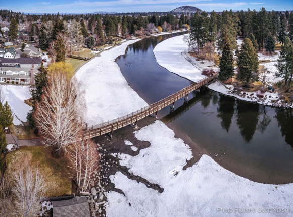 Overhead image of the Deschutes river with frozen snow on the banks.