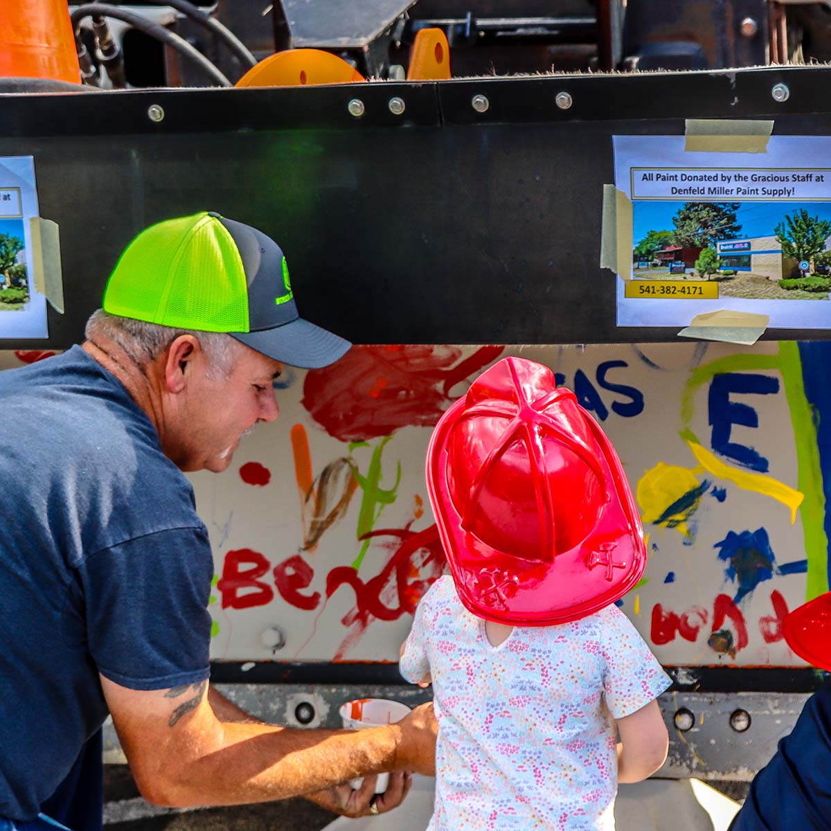 Child painting a City of Bend snowplow blade.