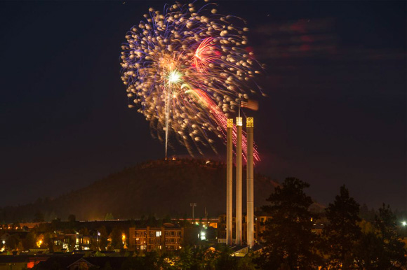 Fireworks over Pilot Butte near the old mill three smokestacks.