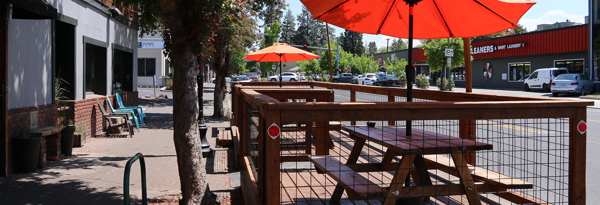 Tables with Umbrellas in parking spaces on a city street