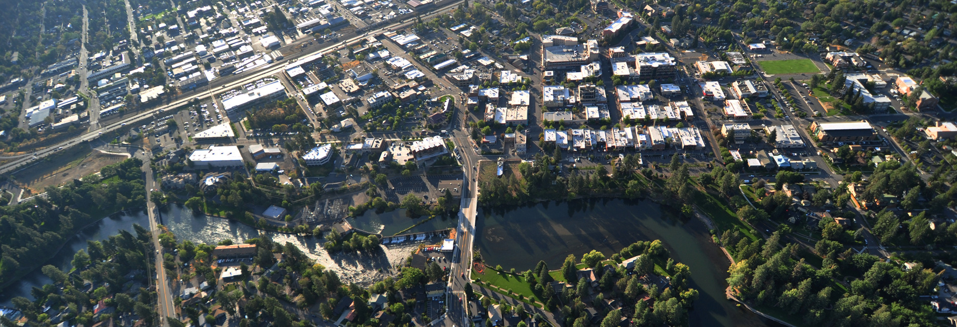 Drone shot of downtown Bend with the Deschutes River and Drake Park in the foreground