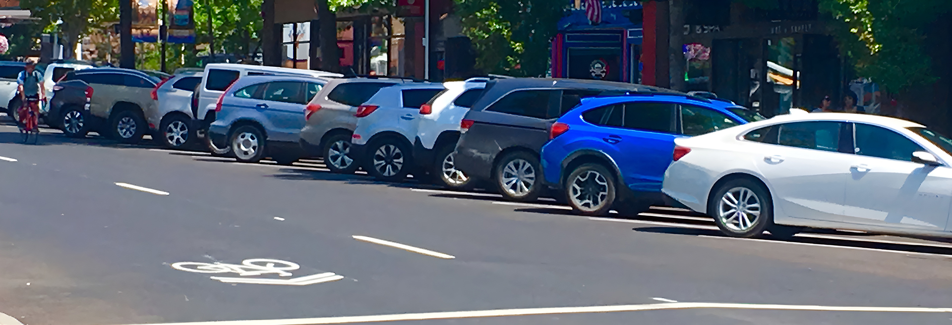 Downtown Bend street with multiple cars parked diagonally along it