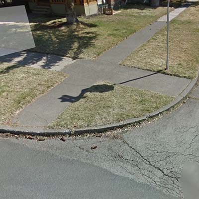 Sidewalk ends in vertical curb, no access to street level (missing curb ramp).