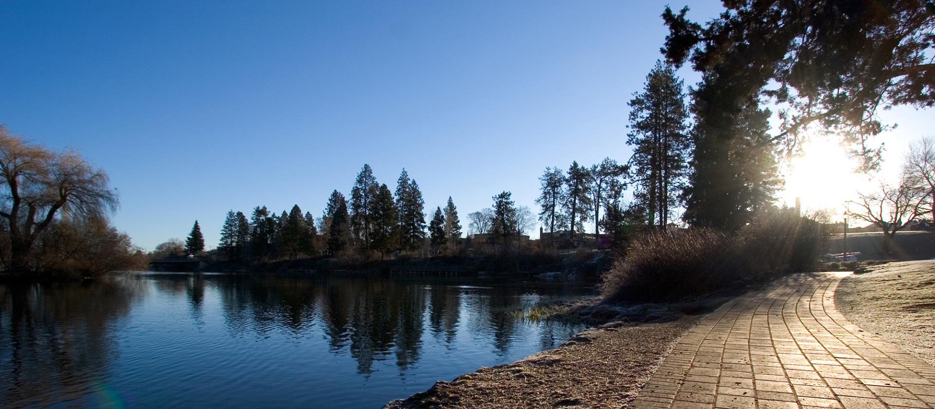 Deschutes River in the fall with sun rising over a path.