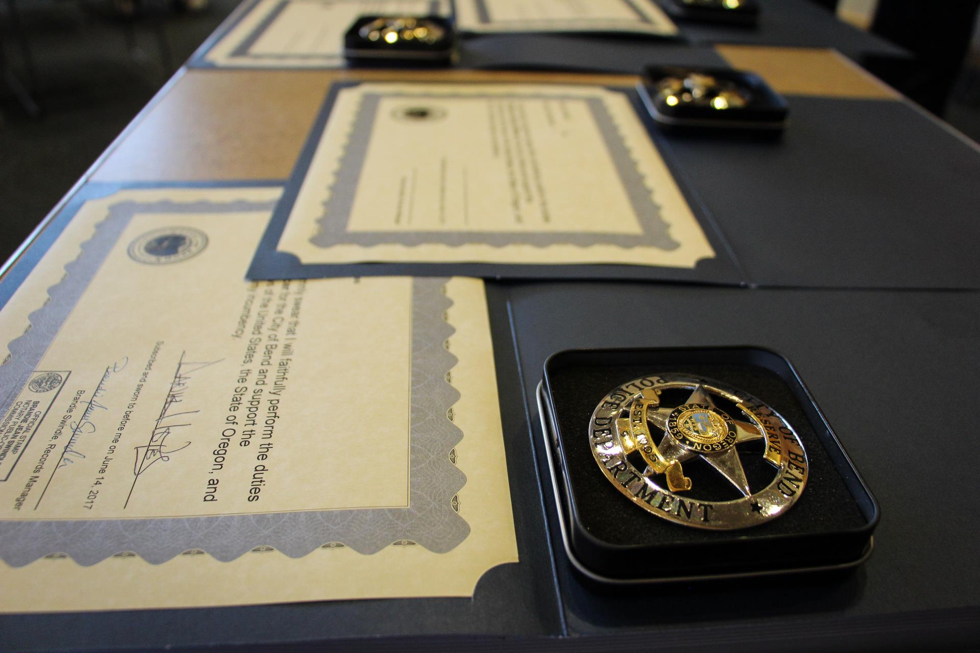 badge and certificates laid out on a table