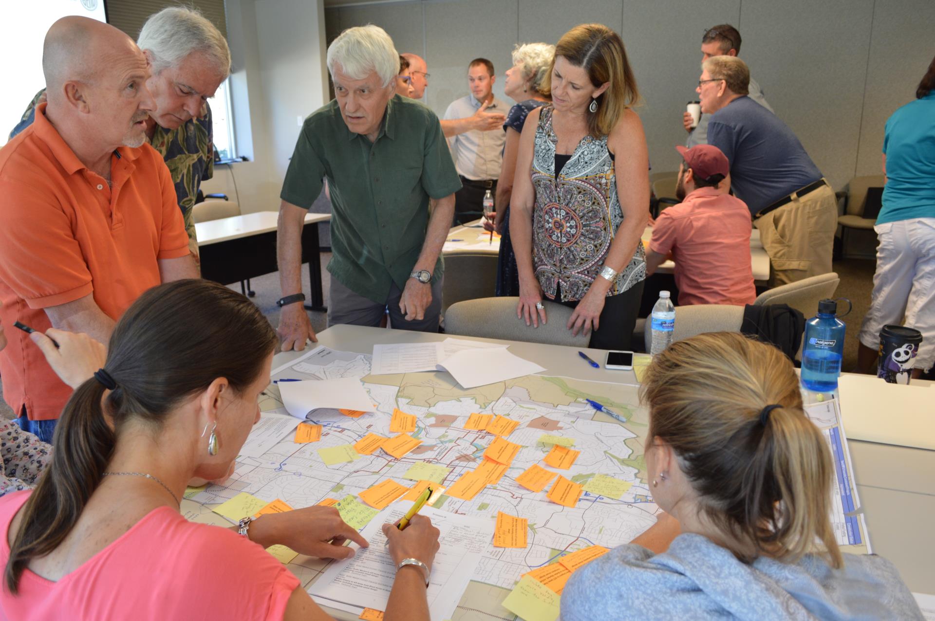 Several member of the Bend MPO Technical Advisory Committee gathered around a map