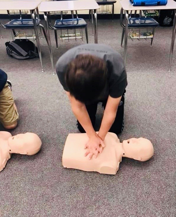 Person doing compression on CPR mannequin