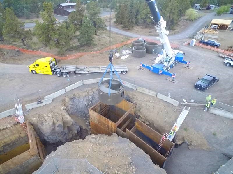 An aerial photo of work crews using a crane to install a diversion manhole near Pioneer Loop.