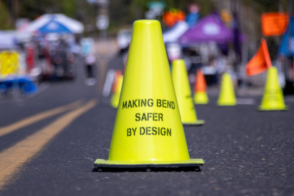 A yellow traffic cone on the street that says 