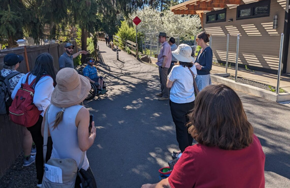People standing on a pathway and in wheelchairs.