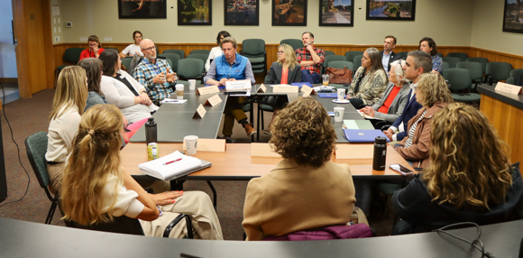 People sitting at a circle of tables.