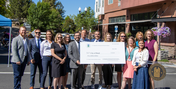 People from the City of Bend holding up a large check for 5 million dollars.