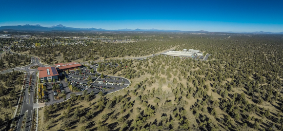 An aerial view of Juniper Ridge with trees and a couple of buildings.