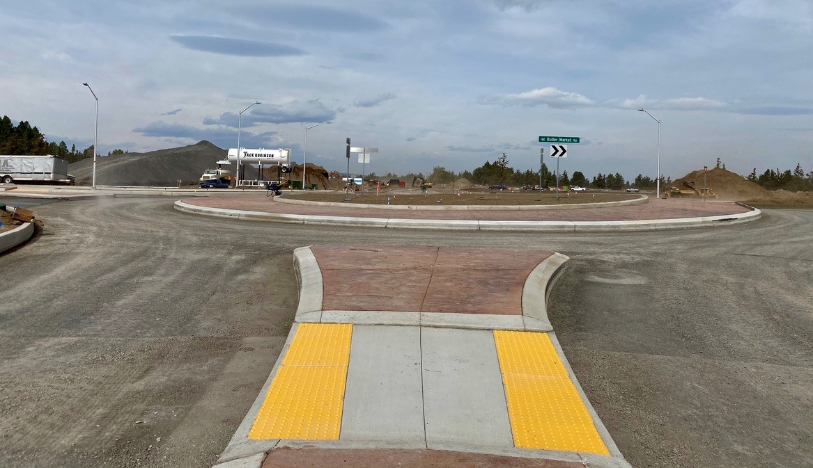 A photo of the Eagle Road & Butler Market Road roundabout with work crews and equipment working in the background.