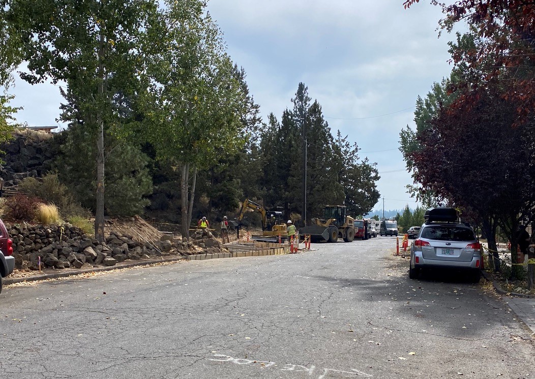 Work crews and equipment working on sidewalk and ADA ramp construction.