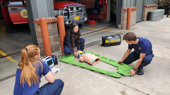 Fire and Rescue crew training on a dummy on the ground.