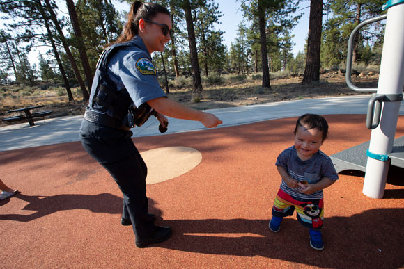 Female police officer hand a small child a sticker
