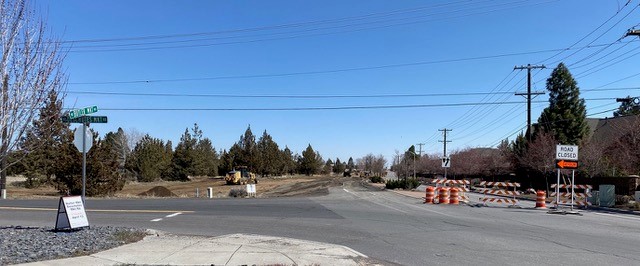 A photo of the Deschutes Market & Butler Market construction site. The photo shows the road closure and detour barricade on Btler Market Rd and construction equipment in the background.