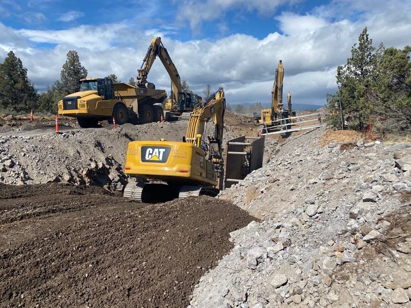 A photo of work crews using large excavation equipment to install pipe at Juniper Ridge.