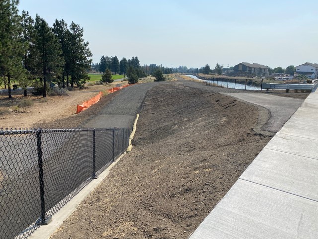 A photo standing from the sidewalk above the Empire extension pedestrian & bicycle undercrossing, looking towards the pedestrian & bicycle paths and the canal.