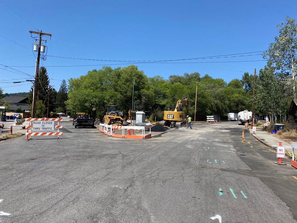 A photo of work crews, equipment, and cones & traffic barricades on NW Riverside & Congress Street.