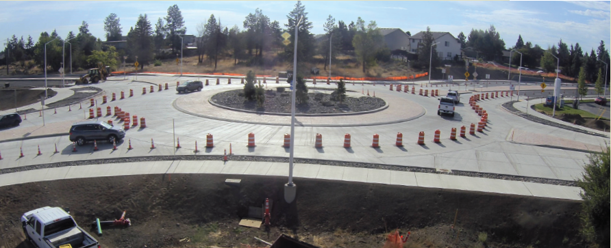 A photo of the new 27th St & Butler Market Rd roundabout open to northbound & southbound traffic. Cones are setup within the roundabout to control traffic and close access for eastbound and westbound traffic.