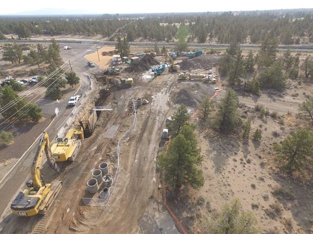 An arerial photo of work crews using large construction equipment for the pipe installation along Pioneer Loop for Segment 2.