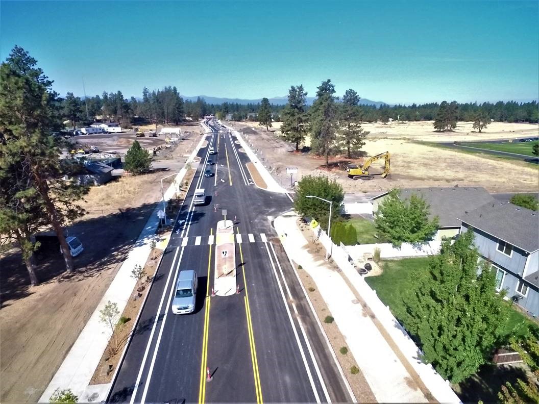 An aerial photo looking west over Murphy Road. There are vehicles using the left lane of Murphy Road and excavation equipment off to the right of the road.
