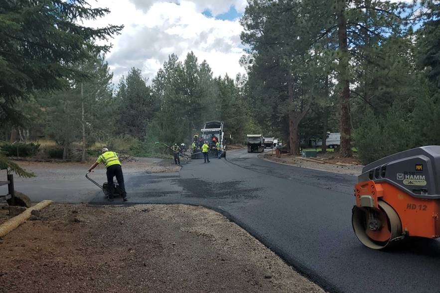 A photo of work crews performing roadway paving on King Hezekiah.