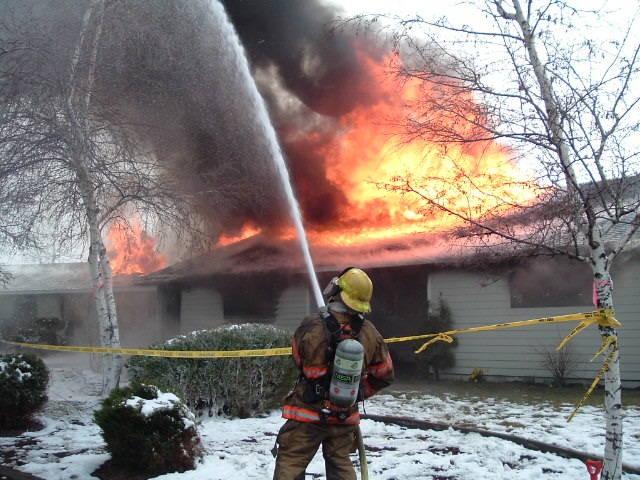 Firefighter spraying water on fire, burn to learn