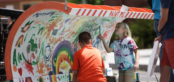 Kids painting a snowplow.