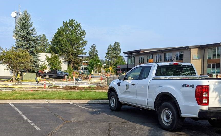 A photo of a City of Bend Inspector overseeing and inspecting the roundabout concrete pour.