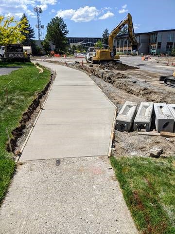 A photo of the new concrete sidewalks poured and curing for pedestrian use.