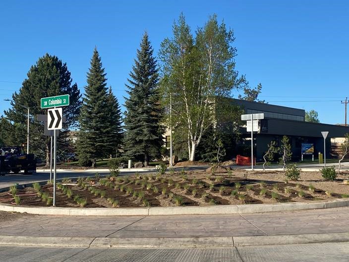 A phot of the completed and landscaped center planter with traffic signs in place.