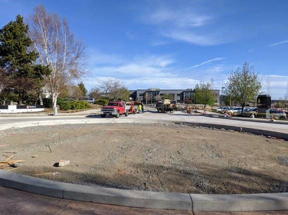 A photo of the north leg of the roundabout on Columbia St. Work crews are sealing the joints in the cement travel lanes.